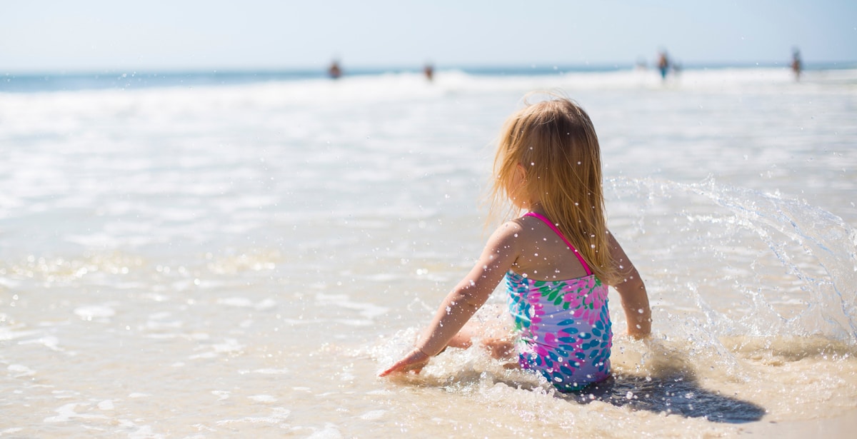 A child sits on the beach in Mexico